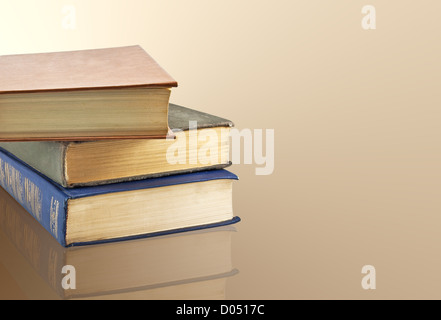 A stack of old books on the reflective surface Stock Photo