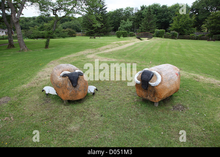 two carved wooden sheep seen by the roadside in Stornaway on the Isle of Lewis in the outer hebrides Stock Photo