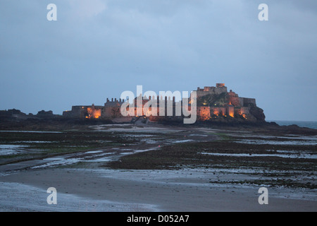 Elizabeth castle, St Helier, Jersey photographed at sunset at low tide showing artificial lighting and rock pools Stock Photo