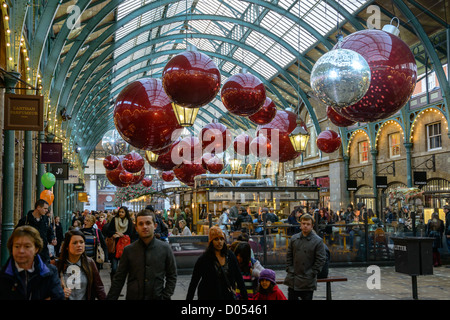 Shoppers at Christmas decorated market in Covent Garden, London, England, UK, 2012 Stock Photo