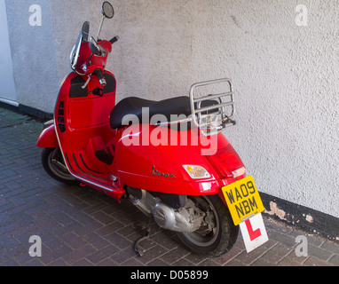 Honiton Devon England. October 14th 2013. A red Vespa scooter parked on an alleyway. Stock Photo