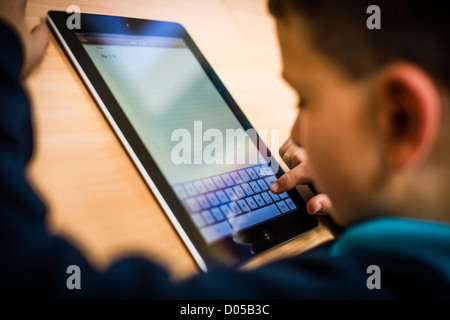 Children using Apple iPad tablet computers at a new community primary school Wales UK Stock Photo