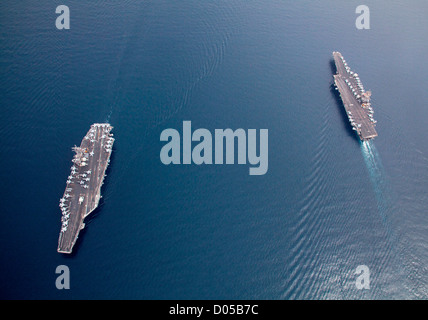 The Navy’s oldest aircraft carrier USS Enterprise, right, passes the Navy’s newest aircraft carrier USS George HW Bush June 21, 2011 during a transit of the Strait of Bab el Mandeb in the Red Sea. Stock Photo