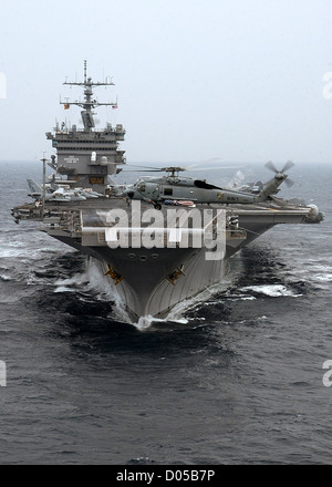 An SH-60F Seahawk passes the bow of USS Enterprise July 7, 2004 as the ship steams through the waters of the Atlantic Ocean following a port visit to Portsmouth, England. Stock Photo