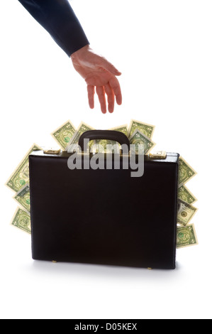 businessman reaching for a briefcase bursting with american dollars Stock Photo