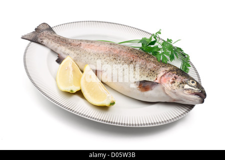 plate with rainbow trout, lemon, and parsley over white background Stock Photo