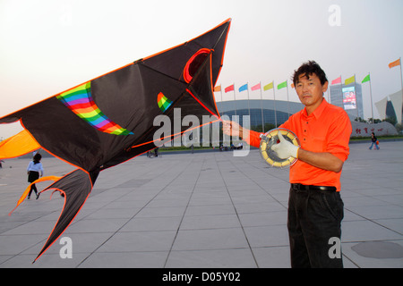 Shanghai China,Chinese Pudong Xin District,Oriental Sports Center,Asian man men male adult adults,delta kite flyer,flying,reel,line,hand wheel,hobby,C Stock Photo