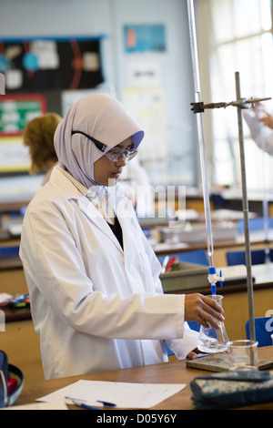 A Muslim girl in a level science chemistry class lesson at a secondary comprehensive school, Wales UK Stock Photo