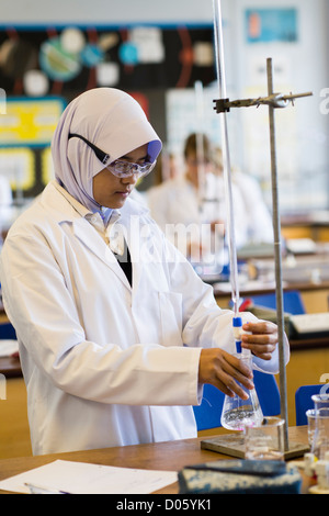 A muslim girl in a chemistry science laboratory lab class practical lesson at a secondary comprehensive school, Wales UK Stock Photo