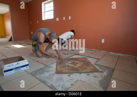 A volunteer lays tile, helping to rebuild a house for a resident seven years after Hurricane Katrina hit New Orleans. Stock Photo