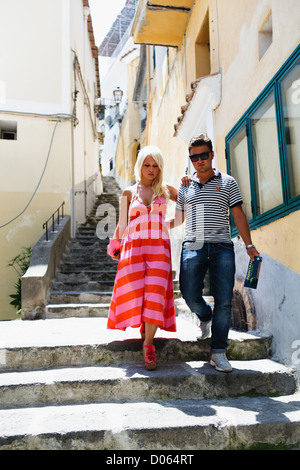 Young Couple Walking Down of Stairs in a Narrow Street, Positano, Campania, Italy Stock Photo