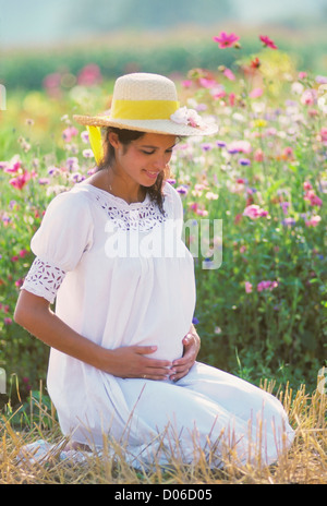 Pregnant woman portrait in flower garden Stock Photo