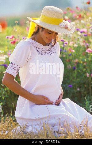 Pregnant woman portrait in flower garden Stock Photo