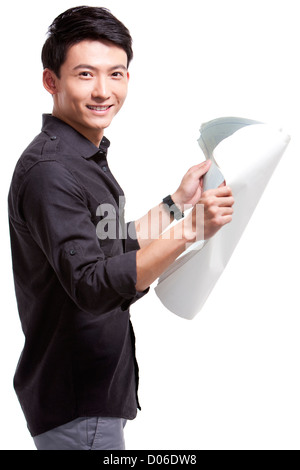 Young man with blueprint looking over shoulder Stock Photo