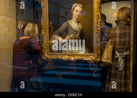 Art lovers are seen through a window while attending a private exhibition preview of a series at Phillip Mould, a dealer of paintings in London. Philip Mould & Company are a leading specialist dealer in British art and Old Masters. Our gallery is located in Dover Street at the centre of London’s art market. They have a large selection of fine paintings for sale, from Tudor and Jacobean panel pictures to eighteenth century landscapes, as well as works by Old Masters such as Titian and Van Dyck, and antique portrait miniatures. Stock Photo