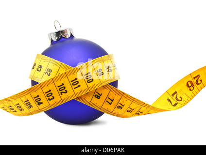 Tape measure around a bauble concept symbolizing Christmas weight gain from eating too much food. Stock Photo