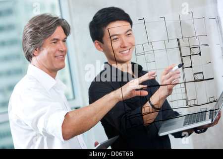 Designers drawing sketch on glass wall Stock Photo