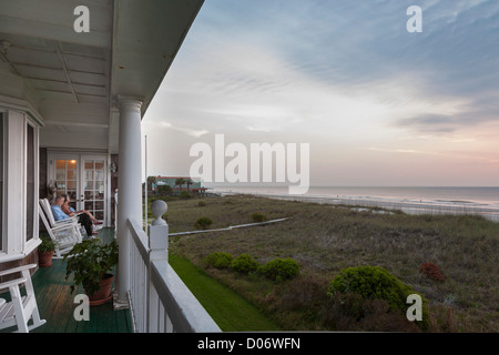 Couple on hotel porch watching sunrise over Atlantic Ocean at Amelia Island, Florida Stock Photo