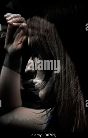 A Young Woman appearing unhappy ,depressed in a creative digital art image in the format of a composite toned monochrome montage