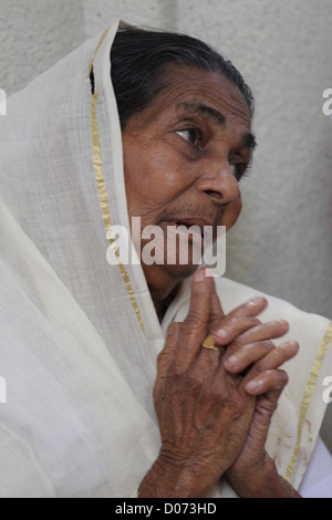 Picture of an old lady worshiping Jesus at the church in Kerala. Stock Photo