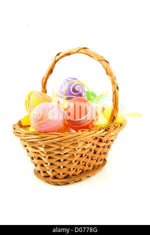 Cane basket with colorful easter eggs over white background Stock Photo