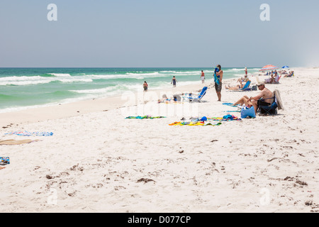 People playing and sunbathing on Gulf of Mexico white sand beach at Gulf Breeze, Florida Stock Photo
