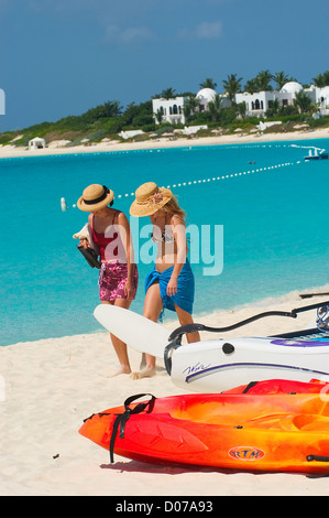 Two guests walk on the white sand beach of the  of the exclusive Cap Juluca  resort, Maundays  Bay, Anguilla, British West Indies Stock Photo