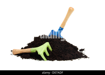 gardening tools and pile of garden soil over white background Stock Photo