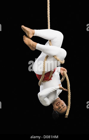 Clown Hanging Upside Down On A Trapeze Stock Photo - Alamy