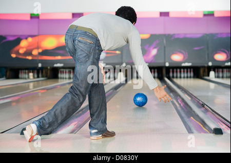 Young man playing ten pin bowling Stock Photo