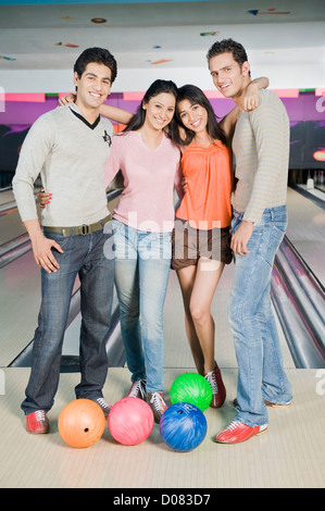 Two young couples with bowling balls in a bowling alley Stock Photo