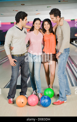 Two young couples with bowling balls in a bowling alley Stock Photo