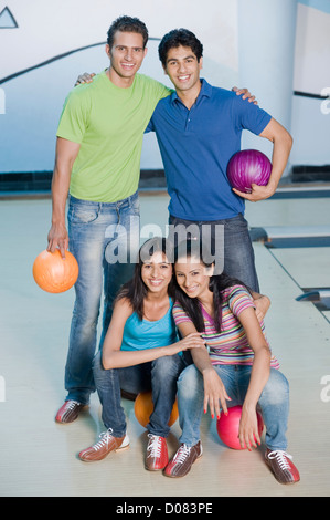 Two young couples with bowling balls in a bowling alley Stock Photo