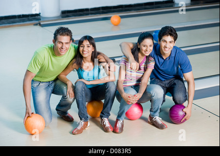 Two young couples with bowling balls in a bowling alley Stock Photo