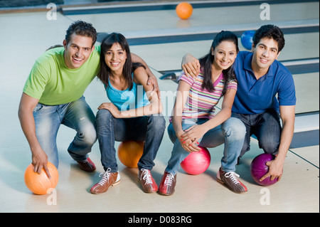 Two young couples with bowling balls in a bowling alley Stock Photo