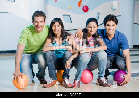 Two young couples with bowling balls in a bowling alley Stock Photo