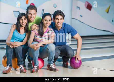 Two young couples with bowling balls in a bowling alley Stock Photo