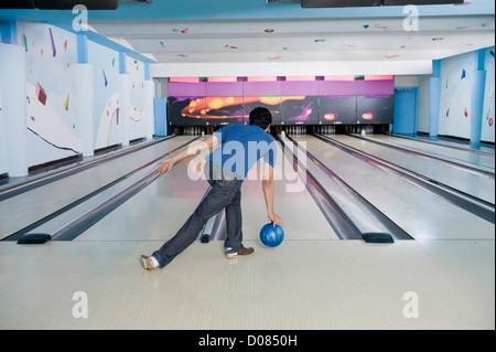 Young man playing ten pin bowling Stock Photo