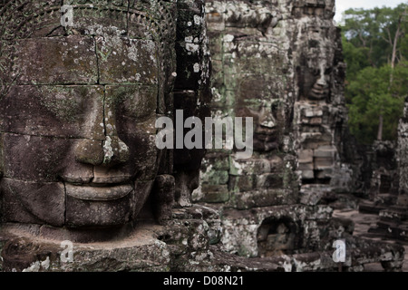 Closeup of the face detail of one in row of famous carved stone head statues in Angkor Wat ancient Prasat Bayon temple ruins Stock Photo