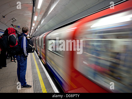 Passenger waits to board Victoria Line underground train, London Stock Photo