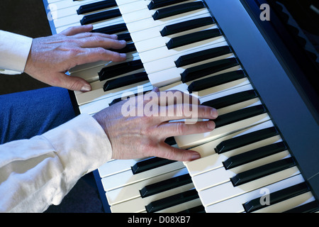 Playing a two manual electric organ. Stock Photo