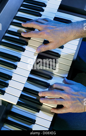 Playing a two manual electric organ. Stock Photo