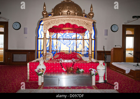 A Takhat Containing the Manji Sahib Covered In Red Silk Rumallas In a Darbar Sahib In A Sikh Temple Stock Photo