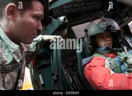 Sgt. Charlie Hollender, a UH-60 Black Hawk crew chief from Mexico, Mo., shows Colin Chasse some of the helicopter's controls during a Nov. 19, 2012 school visit to Simmons Army Airfield, Fort Bragg, N.C. The students, from New Century International Elemen Stock Photo