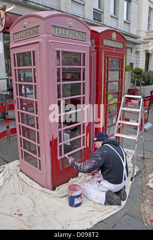 PAINTER PUTTING A BASE COAT ON A TELEPHONE BOOTH NEAR TRAFALGAR SQUARE LONDON ENGLAND GREAT BRITAIN UNITED KINGDOM Stock Photo