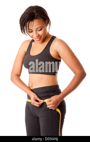 Beautiful happy toned woman weight conscious measuring her size shape around waist hips dressed sporty in grey, isolated. Stock Photo