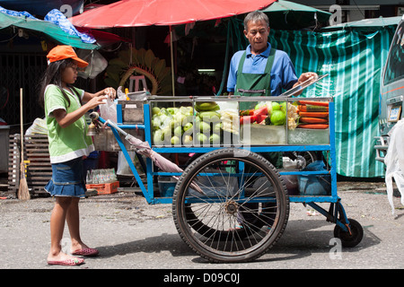 STREET VENDOR SELLING FRUIT ON A STREET IN CHINATOWN BANGKOK THAILAND ASIA Stock Photo