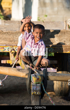 Rural Indian village boys on a bullock cart waving and smiling. Andhra Pradesh, India Stock Photo