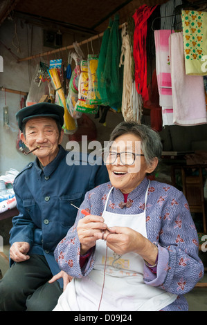 Couple enjoys talking to customers from stall they run at street market in village on outskirts of Chengdu, Sichuan Province, Ch Stock Photo