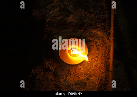 Close up view of a little candle on a rustic wall Stock Photo